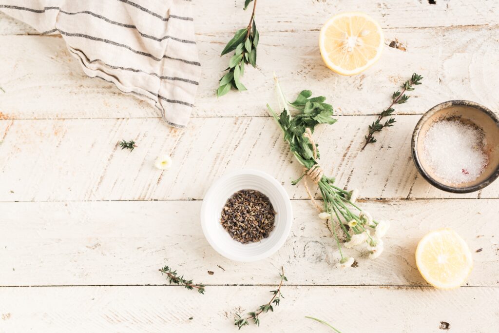 Decorative phot of sprigs of lavender and a jar of salt on wooden background.