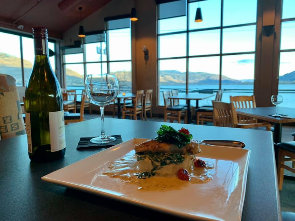 Food on a table in a restaurant overlooking a lake.